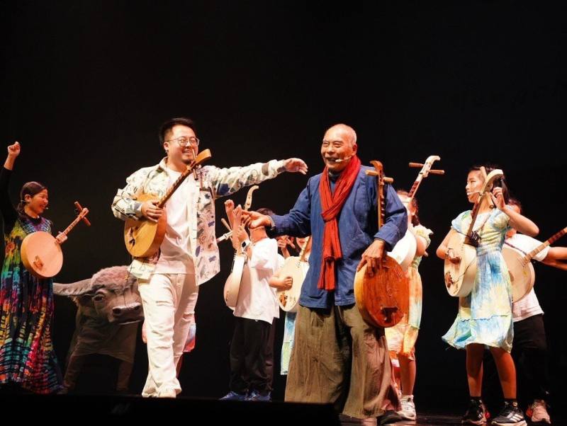 紙風車劇團31日在屏東恆春文化中心劇場館演出，邀請屏東子弟加入共演「屏東幻想曲」，現場並帶領墾丁國小學生進行月琴彈唱。（紙風車劇團提供）