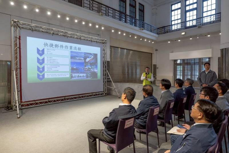 總統抵達後，首先聽取臺北郵局張清龍經理簡報快捷郵件「收、封、運、投」之作業流程