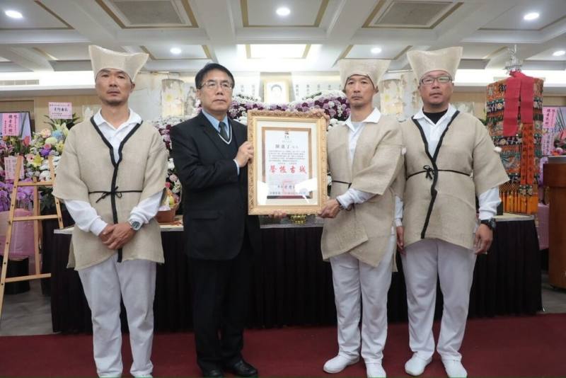台南市列冊傳統表演藝術「南管」保存團體「振聲社」前社長、資深造船匠師陳進丁日前辭世，台南市長黃偉哲（左2）4日親赴公祭會場頒發「卓越市民」表揚，由家屬代表受贈。（台南市政府提供）