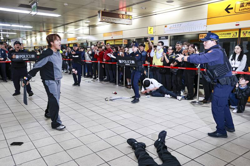 台北市政府、新北市政府5日下午在台北捷運大橋頭站及三重國小站辦理第3階段的「高強度無差別攻擊危安實兵演練」，模擬歹徒持刀攻擊月台旅客，警方立即到場與歹徒對峙。中央社記者鄭清元攝