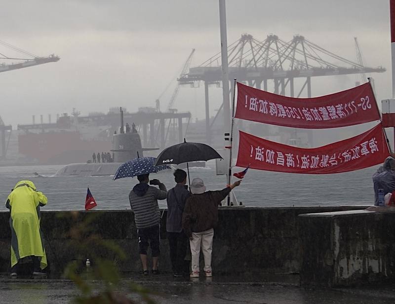 潛艦國造原型艦海鯤艦連續2天進行潛航測試，6日高雄下起陣雨，但大雨未澆熄軍事迷的熱情，依舊拉開紅布條為海鯤艦加油打氣。中央社記者董俊志攝