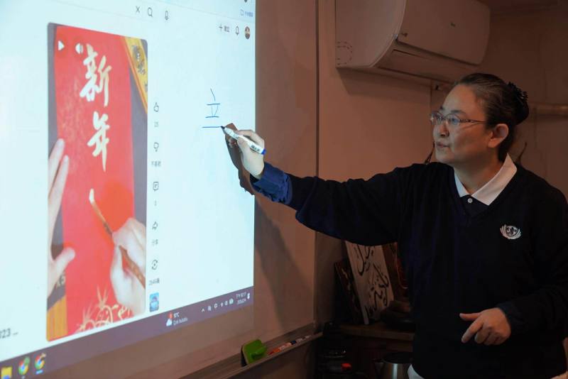 課程中，周如意運用字卡與海報，引導學生認識新年吉祥話，並示範書寫方式