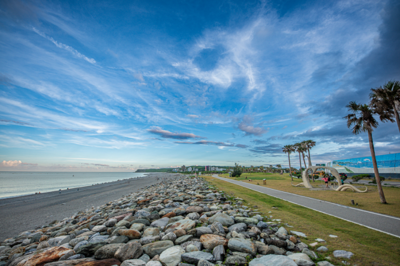 漫步於七星潭濱海步道，遠眺層層山巒與遼闊太平洋交織而成的壯麗景緻，感受山海相依的自然魅力與東部特有的悠然節奏