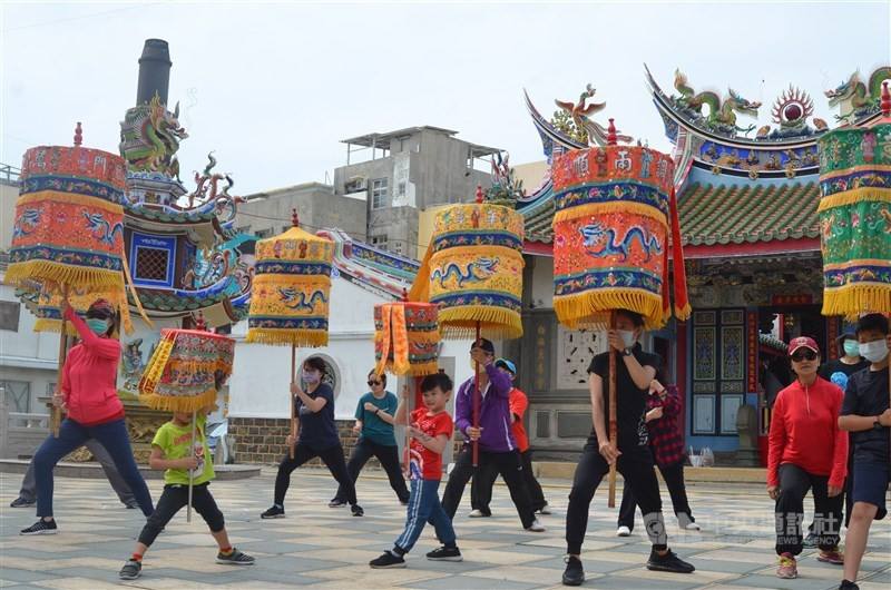 Visitors to Penghu County's Magong experience "parasol spinning," a traditional performance art in the region, in this CNA file photo.