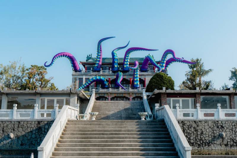 為配合高雄澄清湖的空間整理與果嶺自然公園開放，市府邀請英國藝術家痞子路克（Filthy Luker）參與藝術策展。圖為位於澄清湖遊客中心作品「章魚來襲」，當風吹動時，章魚觸手會隨風擺動。（高雄市文化局提供）