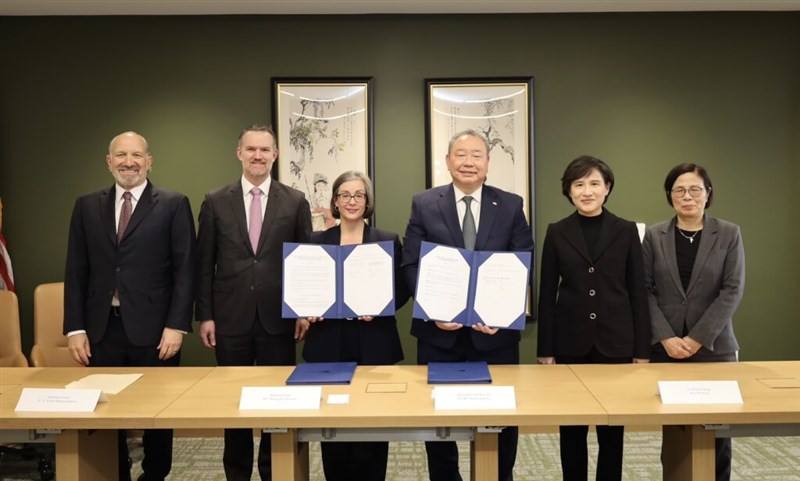 Taiwan's representative to the U.S., Alexander Yui (third right), and Ingrid Larson (third left), managing director of AIT, display copies of the agreement signed by the two sides. Photo courtesy of the Executive Yuan