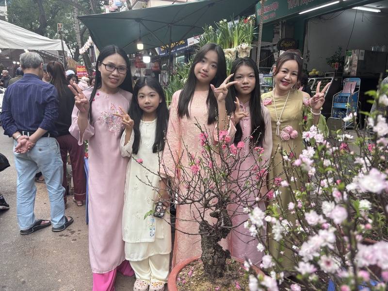 不少河內市民藉著百花齊放之時，穿著奧黛到花市拍照。他們向記者表示，平常沒有買花的習慣，但新的一年買鮮花盆栽能帶來好運，必須要買。