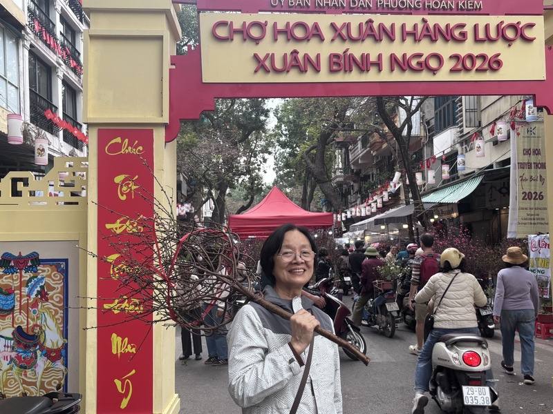 河內老街區的Hàng Lược花卉市集15日一早就湧進了機車與行人，許多民眾高舉剛買來的戰利品桃樹枝，準備帶回家妝點。