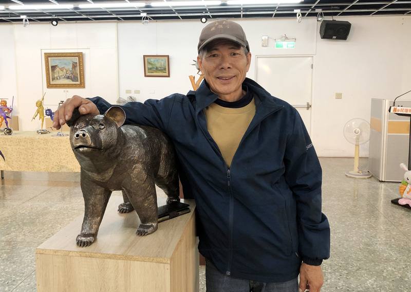 「嘉義鐵孩子」賴銘傳在少年時期就懷抱藝術家夢想，之後為生計從事廣告招牌業多年，直到中年重新找回初心、從事鐵雕藝術。圖為賴銘傳與作品台灣黑熊合影。