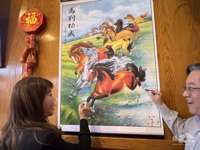 僑務委員盧蔓菁與李延志在馬到功成畫軸簽到合影