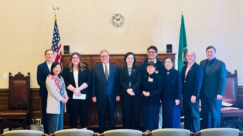 駐西雅圖辦事處長林美呈（中）代表台灣捐款協助美國華盛頓州賑濟救災，華州副州長赫克（後排左3）等政要共同見證。（駐西雅圖辦事處提供）