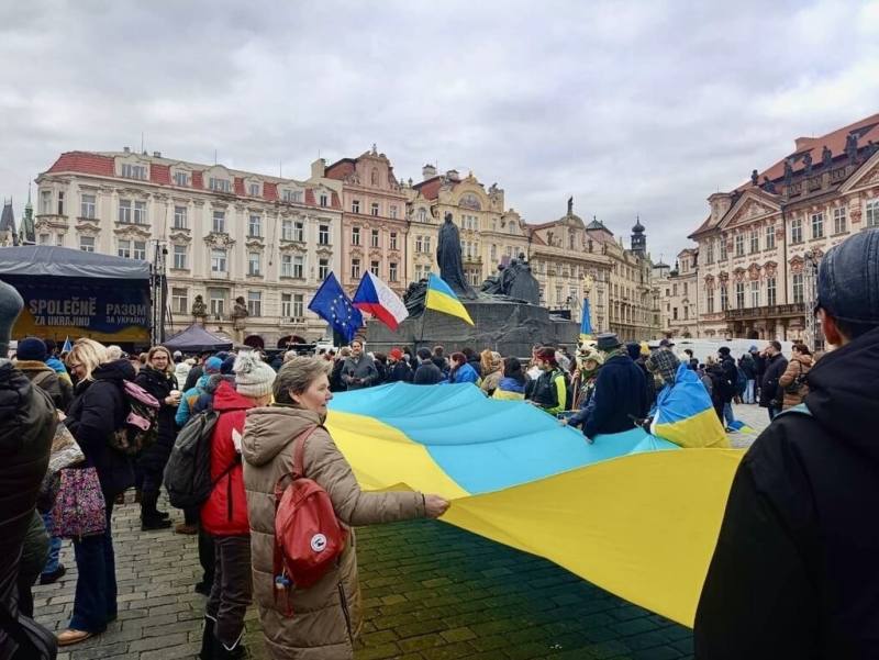 俄羅斯入侵烏克蘭將滿4年，數百人21日在布拉格舊城廣場參加「共同為烏克蘭！」集會。現場多位參與者共同拉著大型烏克蘭國旗布條。　（民眾提供）