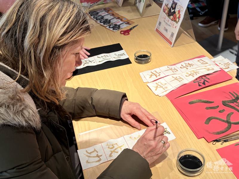 當地居民認真體驗華語文化，書寫「馬到成功」
