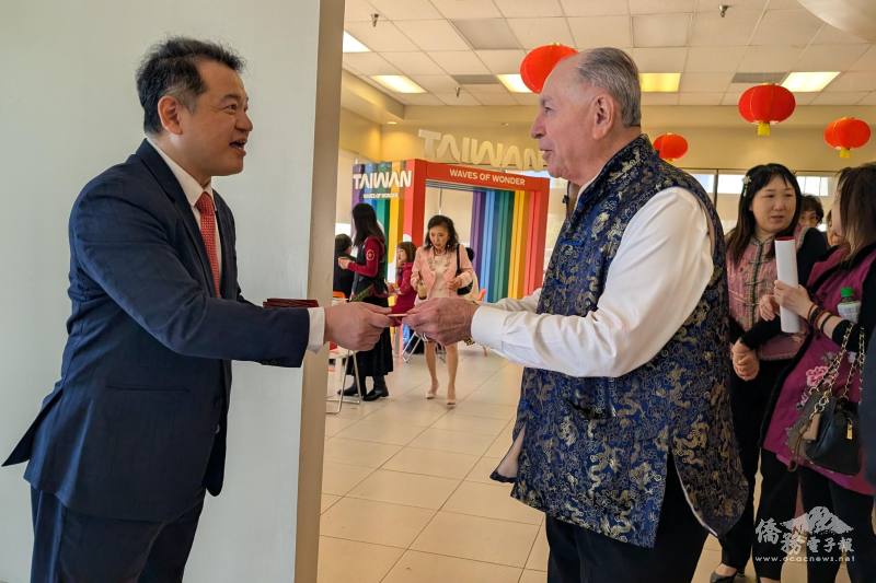 洛杉磯辦事處處長紀欽耀（左）發送「七喜春來」馬年紅包福袋，吸引各族裔領取