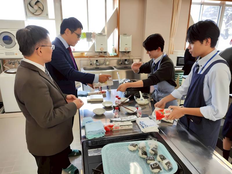 喜多方高校學生帶領訪問團成員體驗飯糰製作過程
