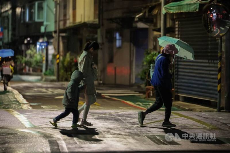 圖為台北市內湖區飄雨，民眾快步前行。（中央社檔案照片）