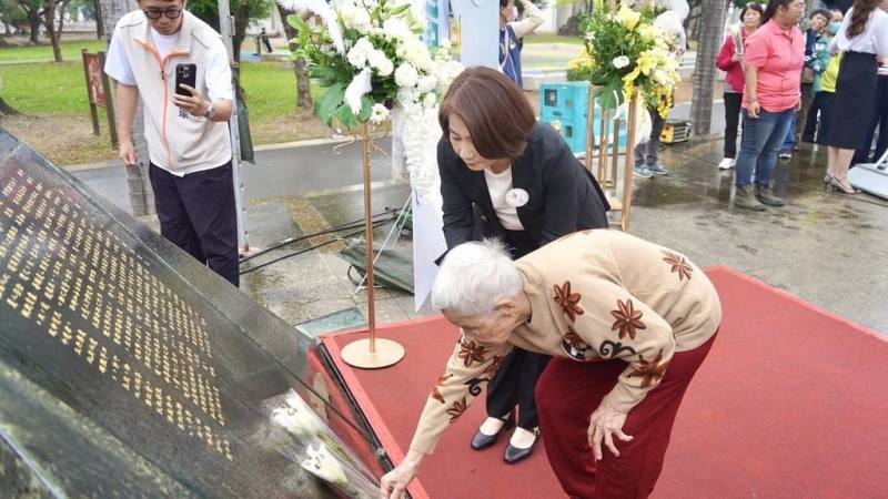 228事件79週年，屏東縣政府28日在屏東公園228紀念碑前舉行和平紀念音樂會，屏東縣長周春米（中後）與受難者家屬張林淑汝（前中）一起向受難者先賢獻上百合花。（屏東縣政府民政處提供）