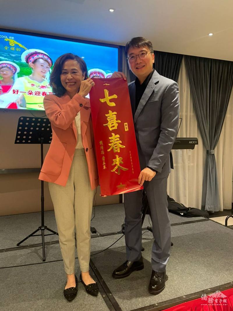 連玉蘋(左)在柔佛州臺灣商會新春晚宴上致贈總統春聯「七喜春來」予會長拿督彭士豪(右)