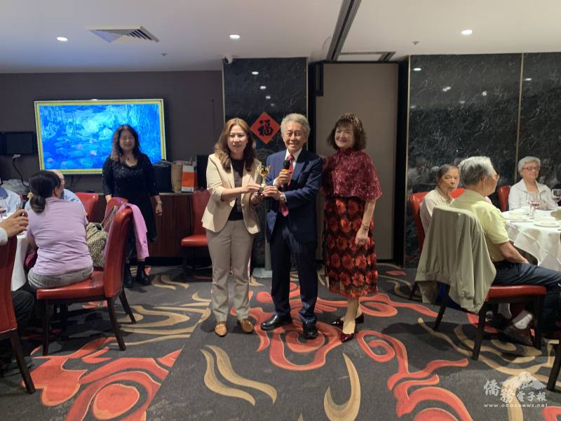 雪梨文教中心江佳慧主任(左)代表微笑之友會頒發紀念贈品予會長林仁堂(中)