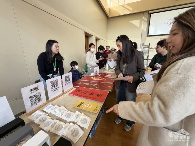 同鄉會提供228百合胸針及2026年「Team Taiwan」春聯，並與「台派寶寶」合作設計年會主視覺與主題貼紙給鄉親們領取