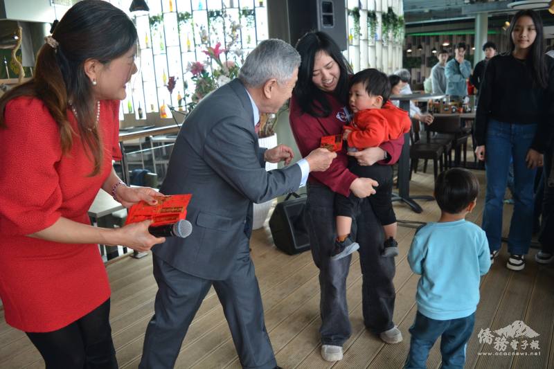 田中光在南荷臺灣廠商聯誼會會長楊千姍陪同下，向旅荷鄉親發送紅包