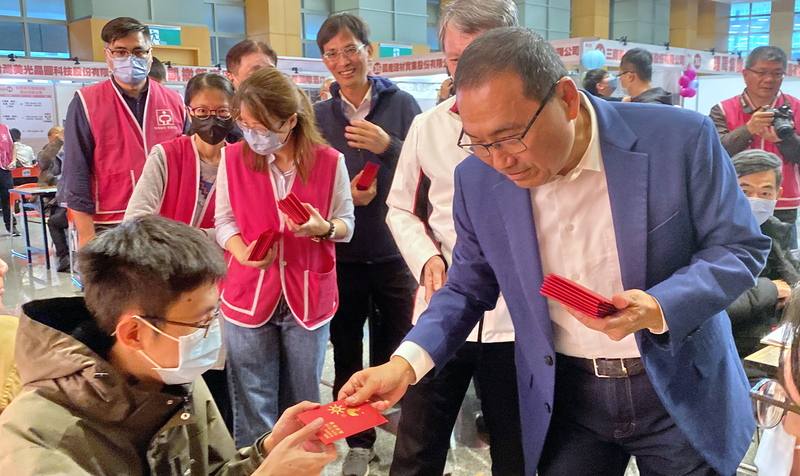 新北市勞工局3日在市府大禮堂舉辦「2026新北市新春就業博覽會」，市長侯友宜（前右）到場發放福袋，祝福廠商找到合適人才，也祝求職民眾順利找到理想工作。