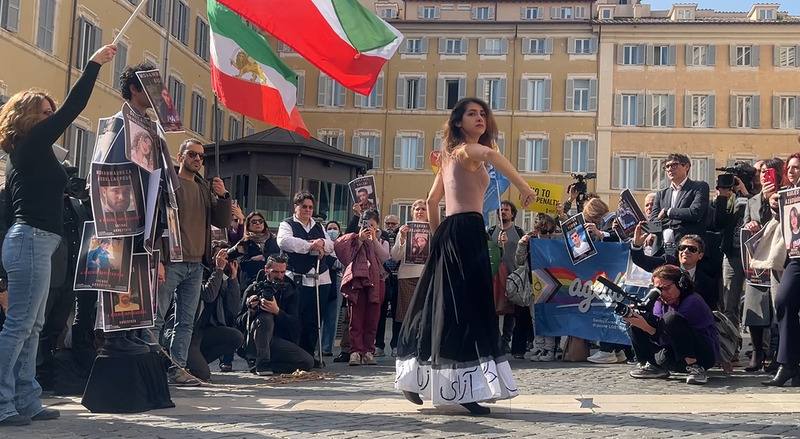 義大利國會前的廣場3日舉行一場快閃活動，呼籲各界施壓伊朗釋放成千上萬的政治犯。圖為快閃行動中的表演，伊朗青年身上貼滿政治犯照片，伊朗女舞者以淒美又具有力量的舞姿表達訴求。