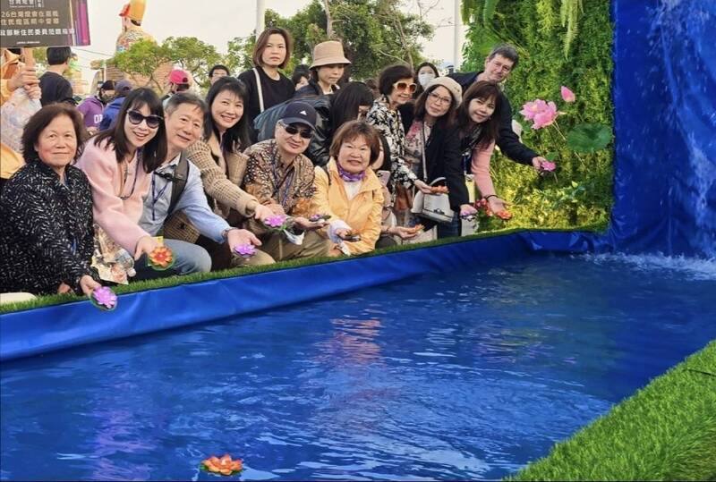 2026台灣燈會在嘉義，會場設有「新住民燈區」，移民署副署長陳建成（前左5）、嘉義縣社會局長張翠瑤（前左6）等人前往參觀，在展出作品「母親河」放置水燈。（移民署提供）