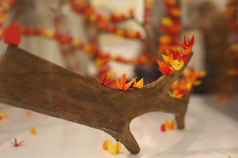 巴西聖保羅僑教中心3月7日舉行慶祝三八國際婦女節活動「台巴藝術交流聯合畫展」開幕式，展出作品「愉悅」（Alegria），藝術家以枯樹枝與迷你摺紙結合，透過自然材質與手工折疊的細節，呈現脆弱與重生並存的情感層次，吸引眾多觀眾駐足。