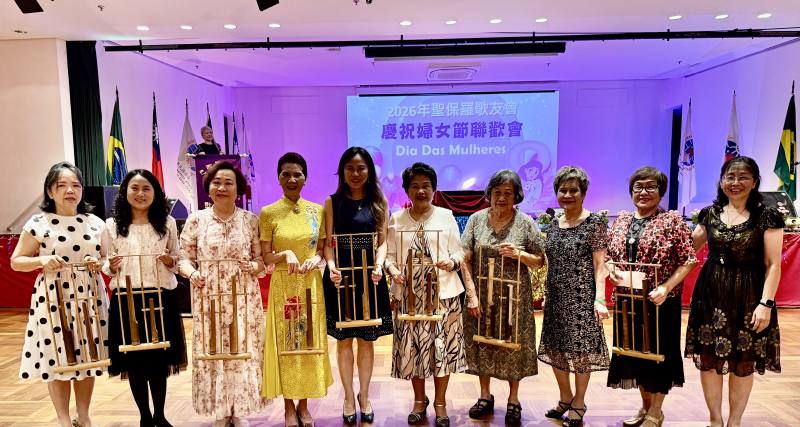 游淑君（右一）介紹由僑胞洪燕玉（右4）所提供的傳統竹筒樂器，並示範演奏生日歌