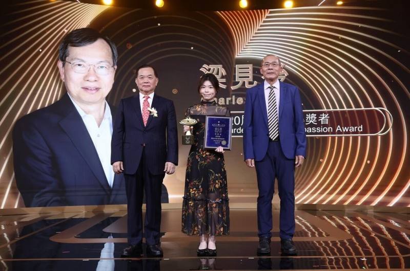 台北科技大學名譽博士、美超微創辦人梁見後獲頒第20屆「愛心獎」，由鐿鈦科技總裁林寳彰（右）頒獎，梁見後女兒（中）代領。（北科大提供）