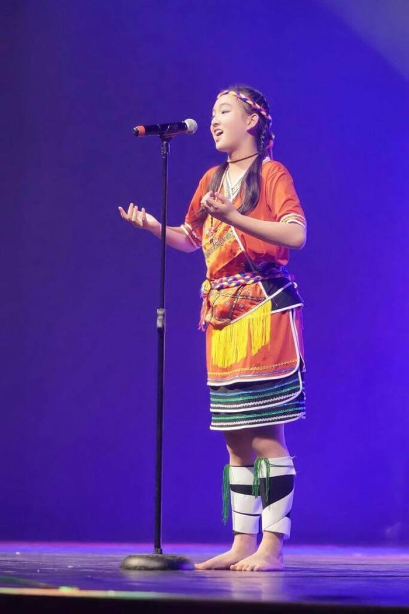 南非台裔少女蔡穎兒身穿台灣原住民族阿美族傳統服飾，在南非表演藝術錦標賽世界音樂項目中演唱「站在高崗上」，展現台灣文化特色。（蔡穎兒父親蔡澤秀提供）
