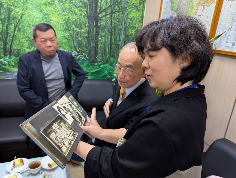 日治時期台中醫師石津坂一的後代石津宏（右2）12日在文史團隊協助下到訪台中市中區戶政事務所，申請父親石津坂一當年戶籍資料，並與戶所人員翻看老照片。