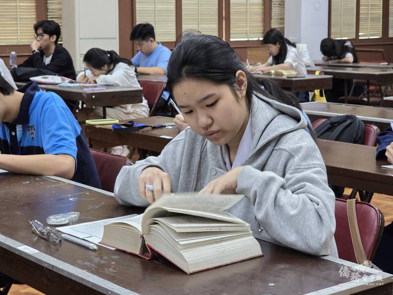 參賽者一邊寫作文，一邊查字典