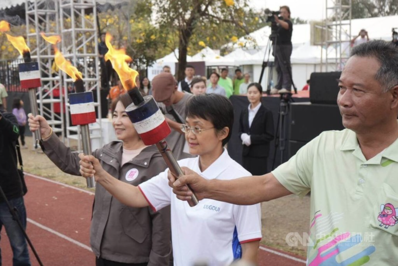 第61屆六堆運動會14日在屏東縣佳冬國中開幕，客委會主委古秀妃（前右2）、屏東縣長周春米（前左）及佳冬鄉長賴文一（前右）一同點燃聖火火把