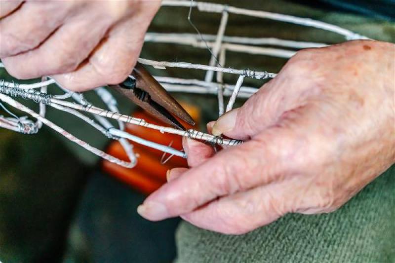 Hsiao carefully shapes the wire frameworks with pliers. As soon as he begins working on a piece, he becomes completely immersed in his own world of festive lanterns.​​