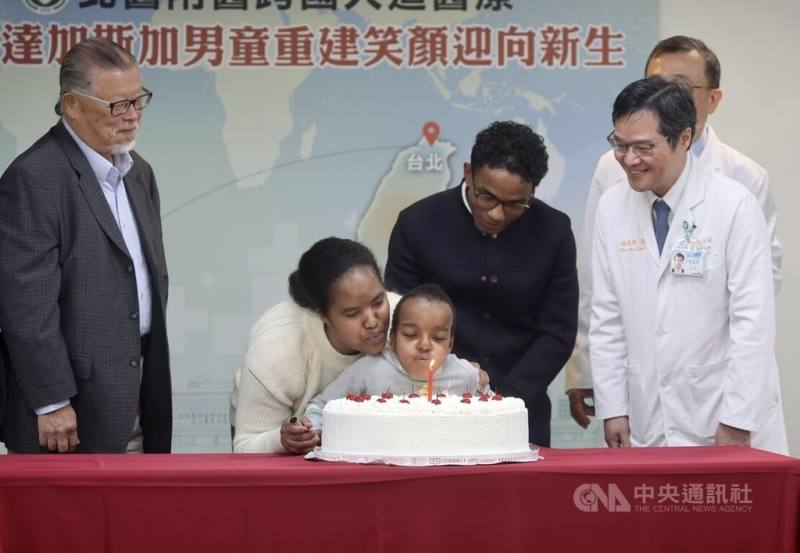 非洲6歲男童Boum（左3）從小受困先天唇顎裂與肢體殘缺，台北醫學大學附設醫院團隊為他擬訂3階段治療計畫，讓他能正常進食、恢復跑跳，院方18日為3月壽星Boum舉辦慶生會，Boum與母親一起吹蠟燭
