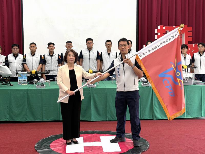 屏東縣警察局20日成立警用無人機隊，由16名取得專業證照警員組成，縣長周春米（前左）授旗，象徵屏東警政邁入全新時代。中央社記者李卉婷攝