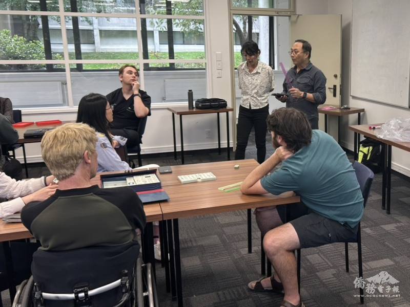 僑務顧問張建中與華興中文班主任方婷儀講解麻將規則