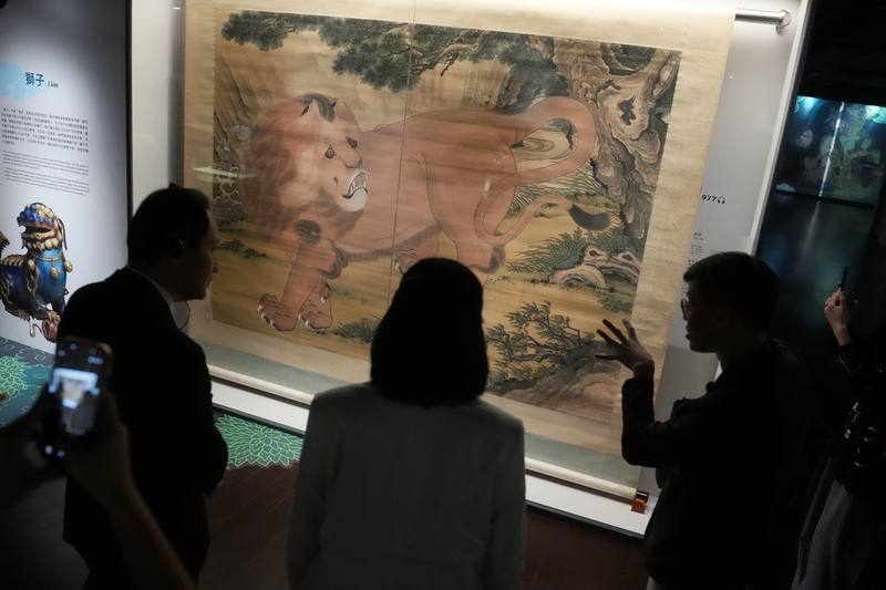 Visitors browse a Qing Dynasty painting of a "Suanni" -- a mythical creature that resembles a lion -- at the National Palace Museum on Monday. CNA photo March 24, 2026
