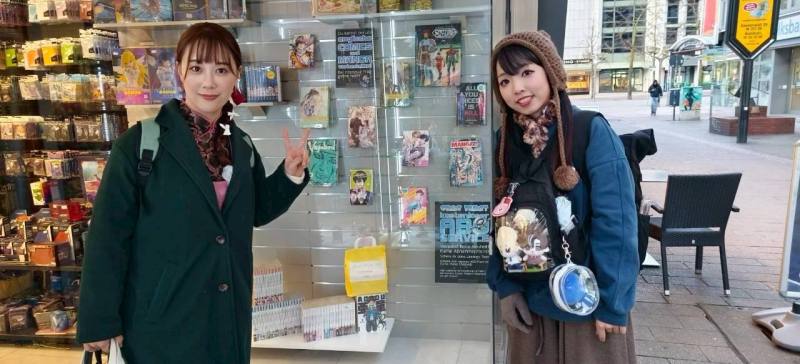 穀子和吳十三兩位漫畫家前往杜易斯堡分享會場，與櫥窗內展售的自己漫畫合影