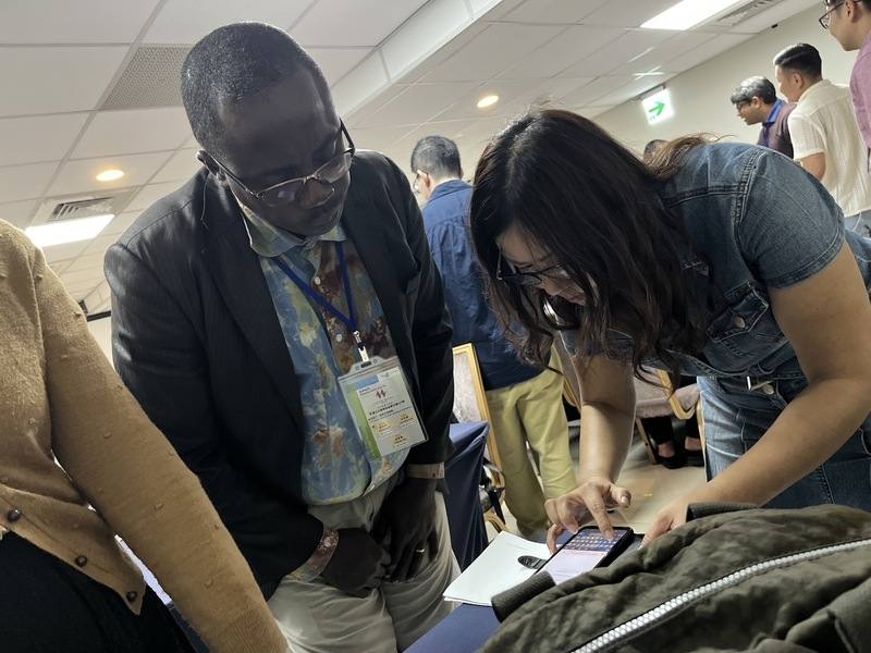 感受到生成式AI使用不當，可能衍生嚴重問題。來自象牙海岸的代表（左）提問整套學習在他返回非洲後是否也能使用，並向授課老師陳妤蓁（右）留下聯絡方式。