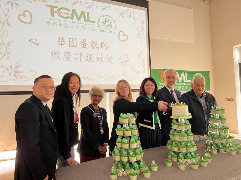 大使姚金祥（右二）、肯特郡長史蒂・朱普與隨扈（中）、東肯華人協會會長陳景滔（右一）、僑務組組長葉帝余（左一）與華園校長曾芳嫻（右三）共同切蛋糕慶祝，見證連續三年榮獲TCML評鑑「最優」的重要時刻。精緻又美味的慶祝蛋糕由旅英珠寶設計師郁蘭（左二）親手製作