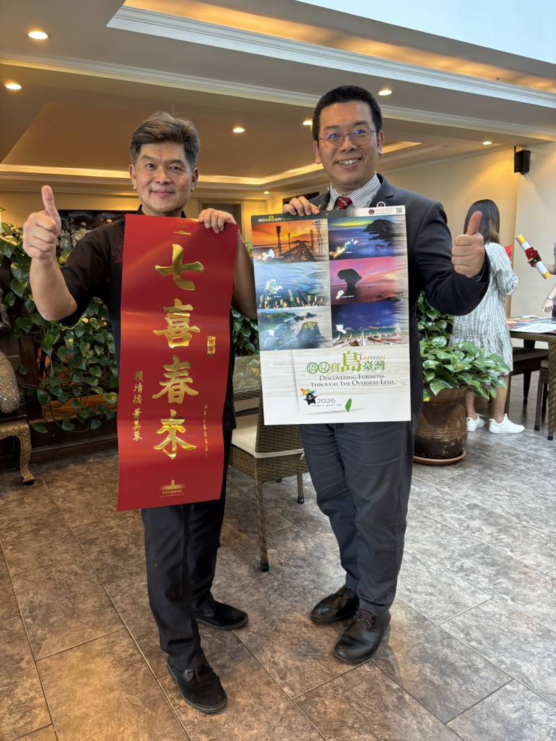 與臺僑潘侃女士共同經營Happy Tembo之Liem T Nguyen(左)歡迎詹前校到訪肯亞且於該餐廳餐敘座談，對於總統府春聯與僑委會月曆讚不絕口