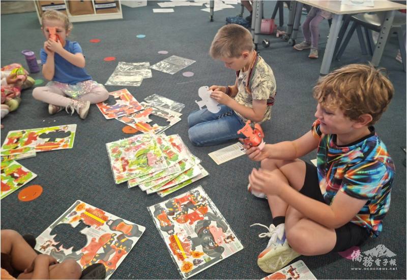 不同族群的孩子們在地毯上共同研究燈籠構造，實踐「Everyone Belongs」的包容精神