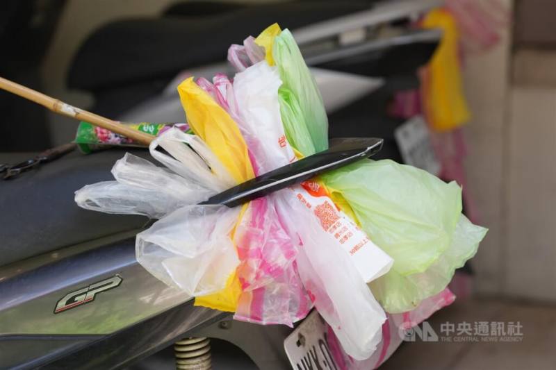 民眾將用過塑膠袋集中塞在機車後扶手上，回收再利用。（中央社檔案照片）