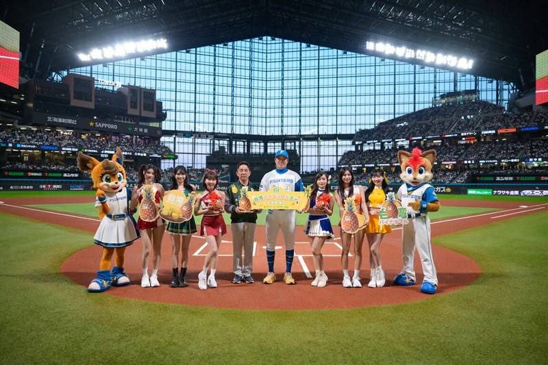 Nippon-Ham Fighters Taiwanese player Gu Lin Ruei-yang (fifth right) and Taiwan's Agriculture and Food Agency Chief Secretary Chen Li-yi (fifth left) pose together with Taiwan's famous baseball cheerleaders inside Es Con Field Hokkaido stadium on Friday to