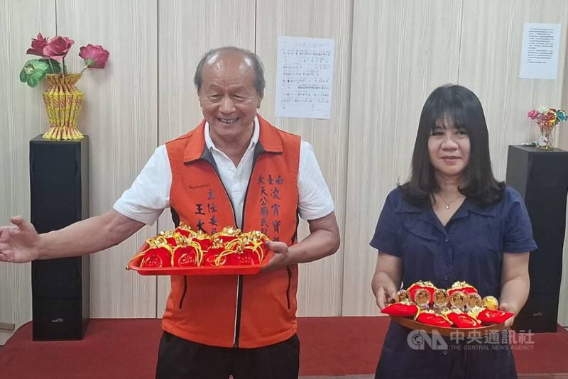 台南市永康區凌霄寶殿武龍宮獲總統賴清德贈匾「保境佑民」，武龍宮主委王大明（左）8日展示廟方製作的限量紀念幣，將於10日贈送給參與揭匾活動民眾。