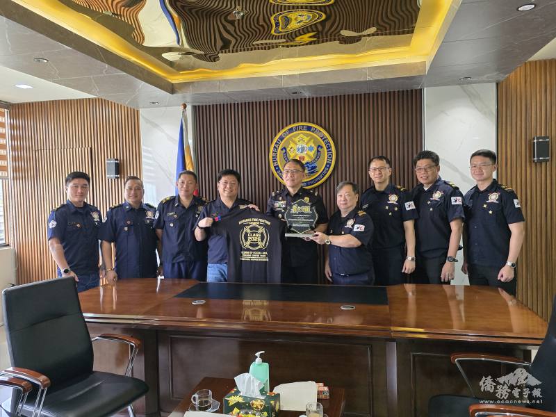 同學會諮詢委員王永鑫（左4）及常務理事蔡彼得（右4）代表菲華文經總會消防研習營同學會，贈送紀念品予菲律賓消防署代署長關張准將（中）