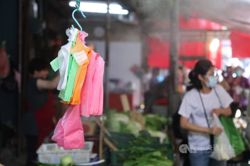 中東戰事牽連石化原料供應，經濟部4月起推動塑膠袋平價專案，本週起將陸續鋪貨進入市場。圖為新北市菜市場攤商準備不同尺寸的塑膠袋供顧客使用。